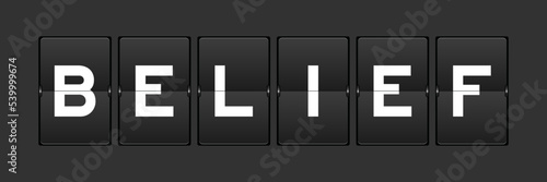 Black color analog flip board with word belief on gray background