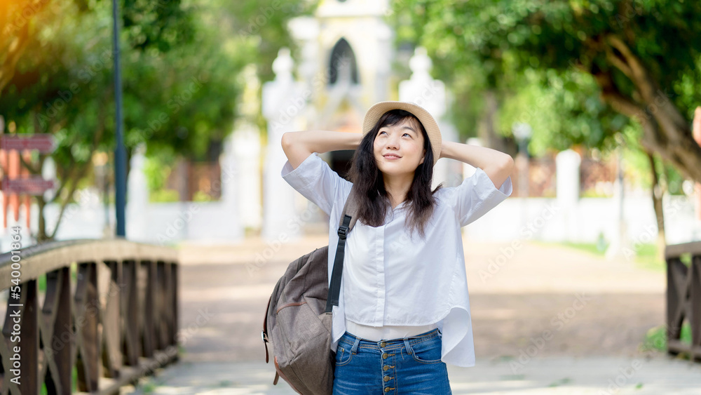 Lifestyle Image of carefree traveling smiling woman in white shirt and  hat spending her leisure time on the temple . Summer mood.