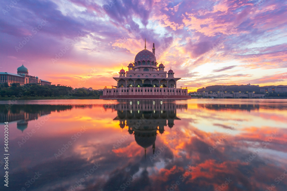 Obraz premium Beautiful sunrise At Putra Mosque, Putrajaya Malaysia with colorful clouds and reflection on the lake surface.