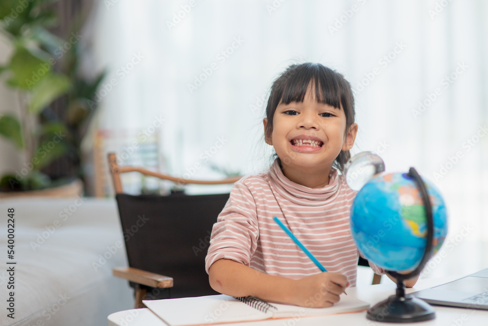 Asian little girl is learning the globe model, concept of save the world and learn through play activity for kid education at home. Asian little girl is learning the globe model, concept of save the world and learn through play activity for kid education at home.
