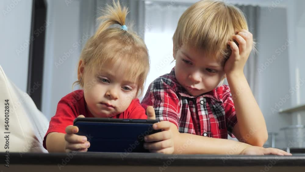 children lifestyle watch online video cartoons on a smartphone. kids little boy and girl brother sister watch online streaming broadcasting the phone children lifestyle watch online video cartoons on a smartphone. kids little boy and girl brother sister watch online streaming broadcasting the phone