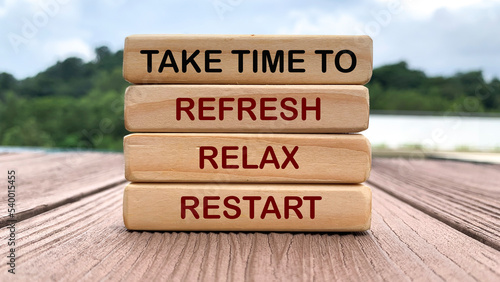 Take time to refresh, relax and restart text on wooden blocks with nature and park background. Time off concept.