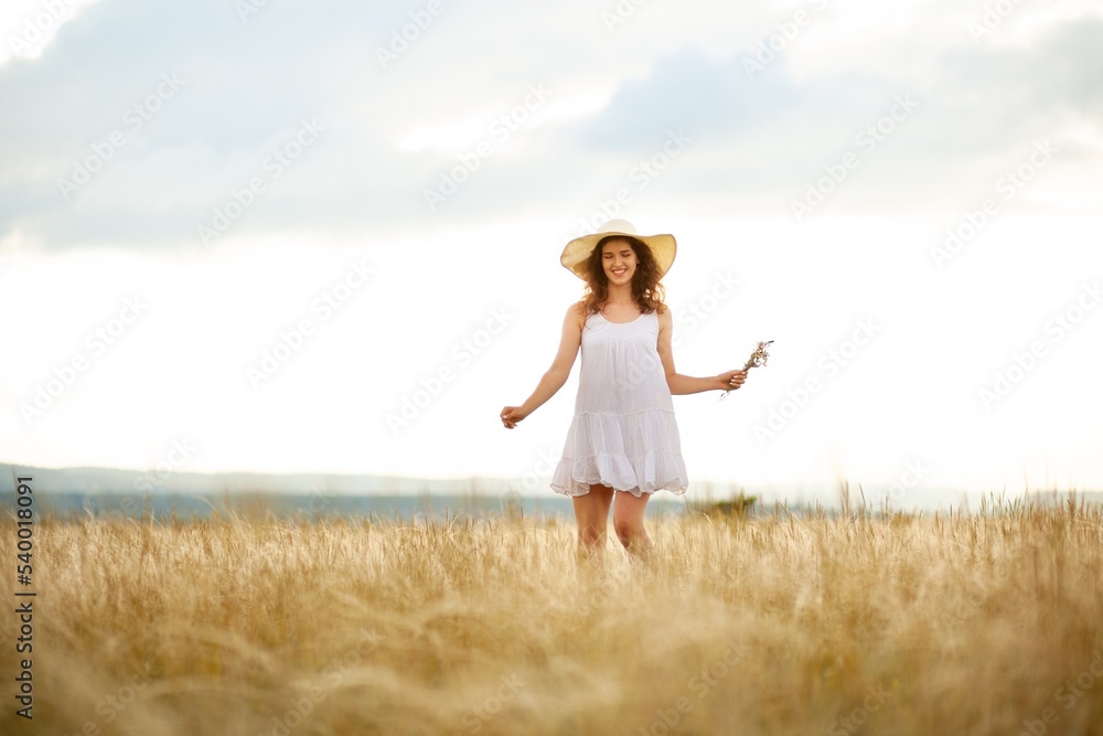 Woman in a hat on field wheat background