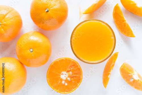 Fresh orange juice in the glass with orange fruit on wood background from top view