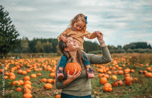Bild auf Leinwand mother and daughter on a field with pumpkins