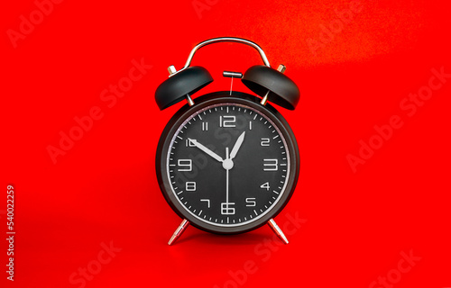black alarm clock on a red background