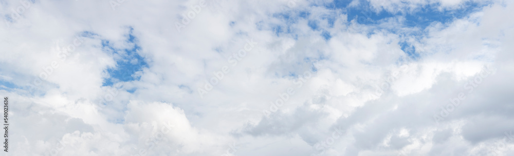Obraz premium Extra large panorama of a sky with white fluffy clouds in front of a blue sky