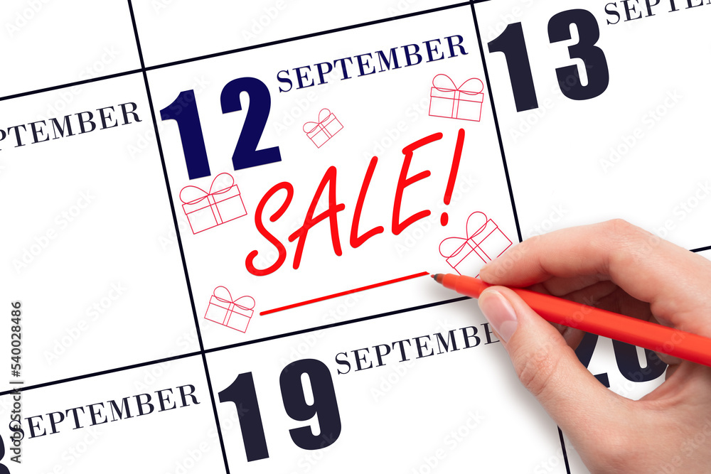 Hand writing text SALE and drawing gift boxes on calendar date September 12. Shopping Reminder Hand writing text SALE and drawing gift boxes on calendar date September 12. Shopping Reminder