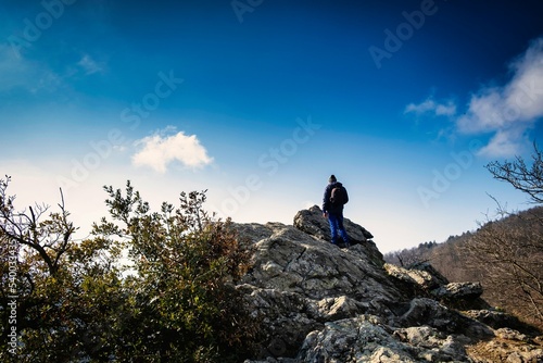 a man observes the horizon from the top of a hill looking towards infinity