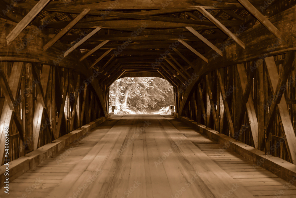 View from inside of an old new England covered bridge in sepia tone. Old wooden planks. Historic covered bridge. Detail view of old wooden bridge planks and beams
