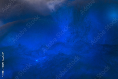 Abstract image made using colored light and cotton snow, artificial snow. Dramatic concept of clouds in the sky, storm at sea, light and dark, atmospheric states. Background or wallpaper.