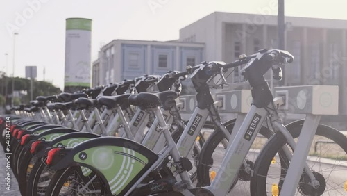 Many public bicycles for rent at bike station on street of Lisbon. Popular rental ecological transport for traveling around city for tourists and citizens. Portugal, Lisboa. July 16, 2022.
