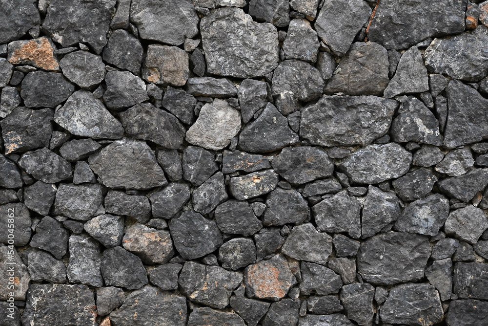 Fondo con detalle y textura de superficie de muro de piedra rustico en tonos grises Fondo con detalle y textura de superficie de muro de piedra rustico en tonos grises
