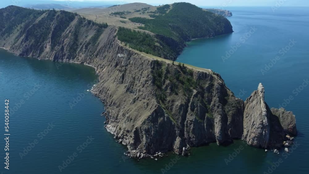 4k Top view of olkhon island and baikal lake in summer irrl. Beautiful aerial of cliffs overgrown with vegetation and surrounded by blue waters outdoors. Picture from drone of amazing landscape and 4k Top view of olkhon island and baikal lake in summer irrl. Beautiful aerial of cliffs overgrown with vegetation and surrounded by blue waters outdoors. Picture from drone of amazing landscape and