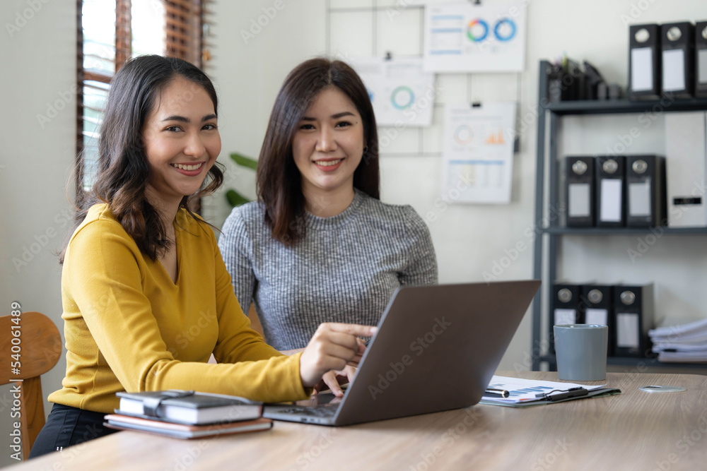 Two young Asian business woman talk, consult, discuss working with new startup project idea presentation analyze plan marketing and investment in the office. Two young Asian business woman talk, consult, discuss working with new startup project idea presentation analyze plan marketing and investment in the office.