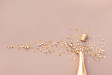 Fashion background with golden champagne bottle, confetti stars, holiday decoration and party streamers in flat lay style. Christmas, birthday or New Year card.