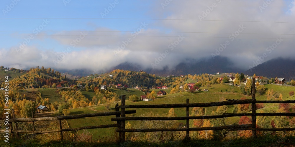 Beautiful sightseeing panorama of Pestera villages from Rucar Bran passage in Transylvania with old and new houses on the hills surrounded by forest. Autumn landscape in Romania.