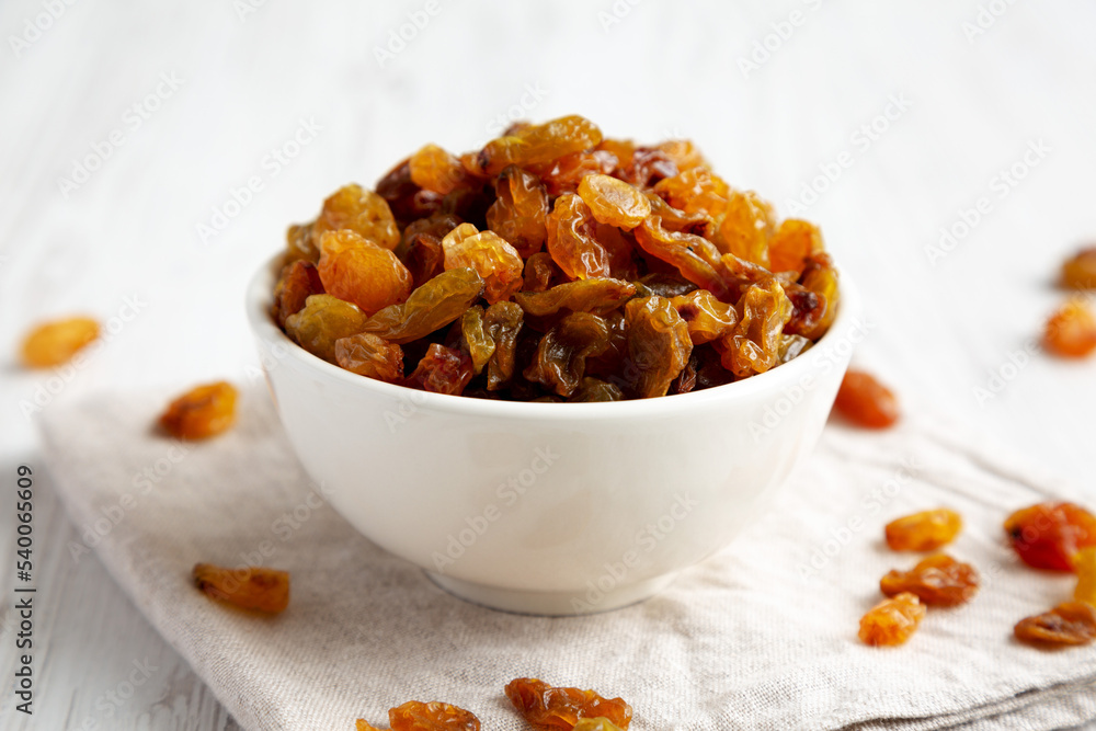 Organic Dried Raisins in a White Bowl, side view.