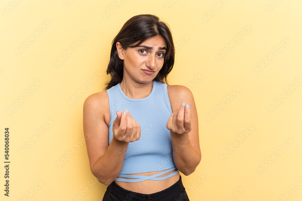 Young Indian woman isolated on yellow background showing that she has no money. Young Indian woman isolated on yellow background showing that she has no money.