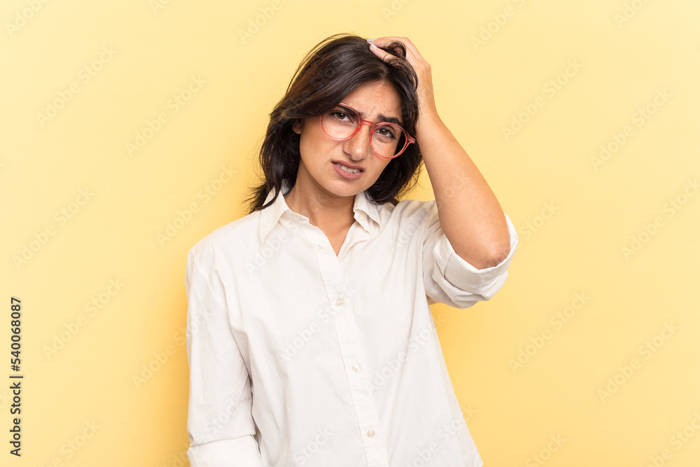 Young Indian woman isolated on yellow background tired and very sleepy keeping hand on head. Young Indian woman isolated on yellow background tired and very sleepy keeping hand on head.