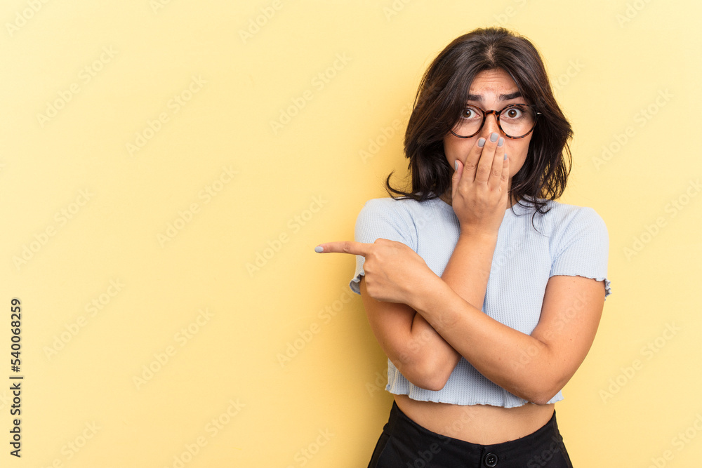Young Indian woman isolated on yellow background pointing to the side Young Indian woman isolated on yellow background pointing to the side