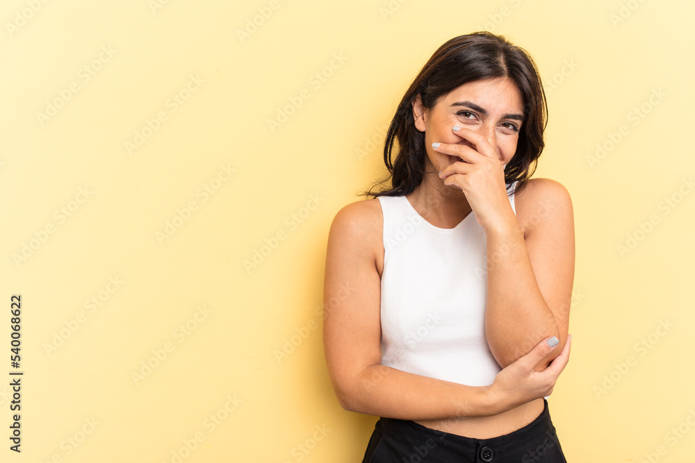 Young Indian woman isolated on yellow background laughing happy, carefree, natural emotion. Young Indian woman isolated on yellow background laughing happy, carefree, natural emotion.