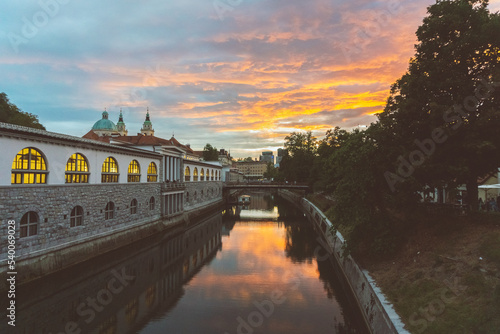 Beautiful sunset over Ljubljanica River with St Nicholas Church and Butcher   s bringe at the background in Ljubljana  Slovenia. Picture made from Dragon Bridge.