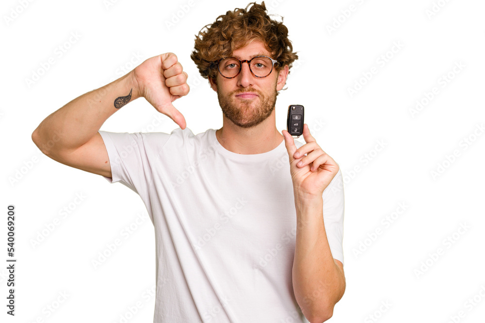 Young caucasian man holding car keys isolated on white background showing a dislike gesture, thumbs down. Disagreement concept. Young caucasian man holding car keys isolated on white background showing a dislike gesture, thumbs down. Disagreement concept.