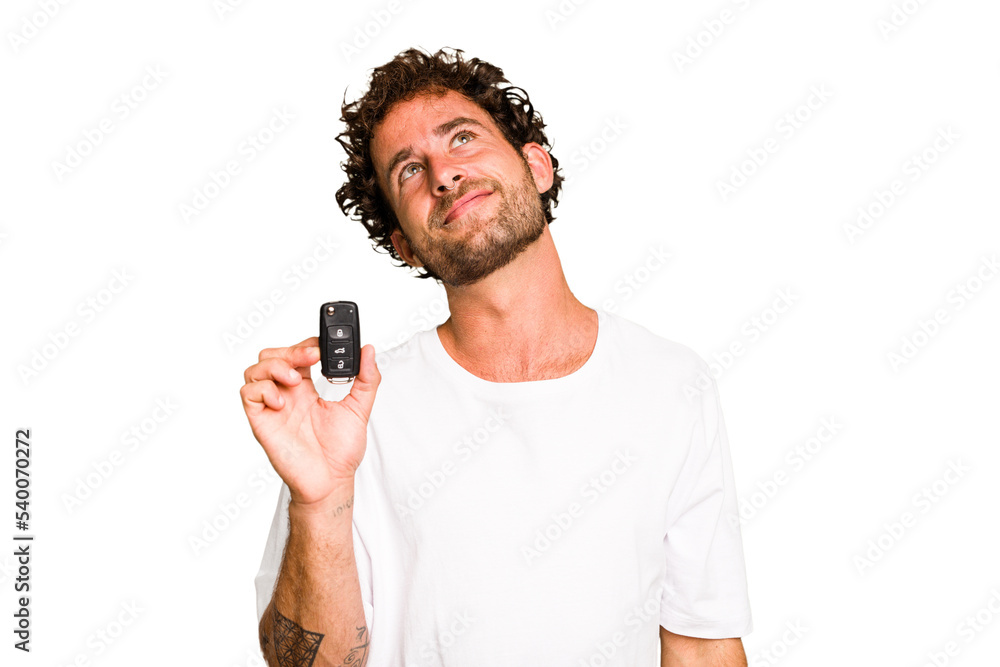 Young caucasian man holding car keys isolated dreaming of achieving goals and purposes Young caucasian man holding car keys isolated dreaming of achieving goals and purposes