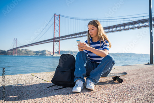 Woman holding mobile phone at the hands and reading message while relaxing