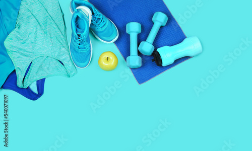 Concept of sportive and healthy  lifestyle including dumbbells, water flash, towel, jogging tops and apple  in fresh colors