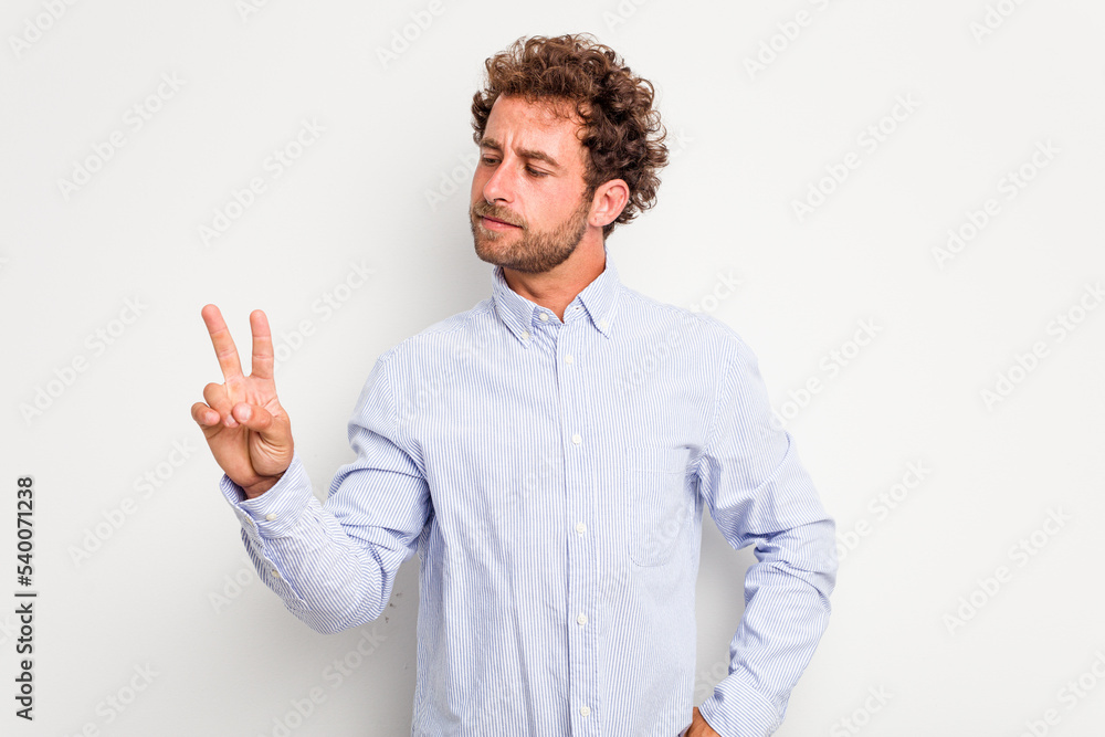 Young caucasian curly hair man isolated on white background joyful and carefree showing a peace symbol with fingers. Young caucasian curly hair man isolated on white background joyful and carefree showing a peace symbol with fingers.