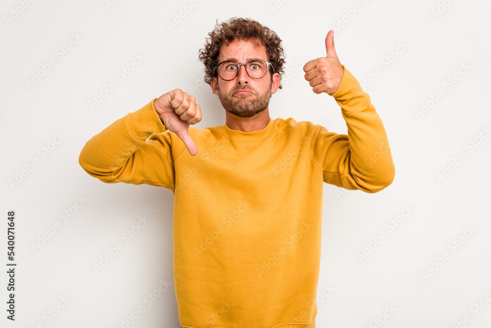 Young caucasian curly hair man isolated on white background showing thumbs up and thumbs down, difficult choose concept Young caucasian curly hair man isolated on white background showing thumbs up and thumbs down, difficult choose concept