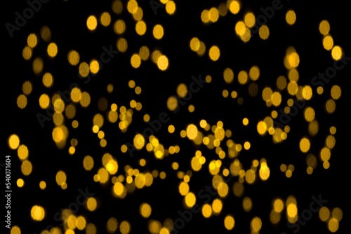 Abstract gold glitter  unfocused  isolated on a black background for overlay design. Golden blurred bokeh light.  Photo.