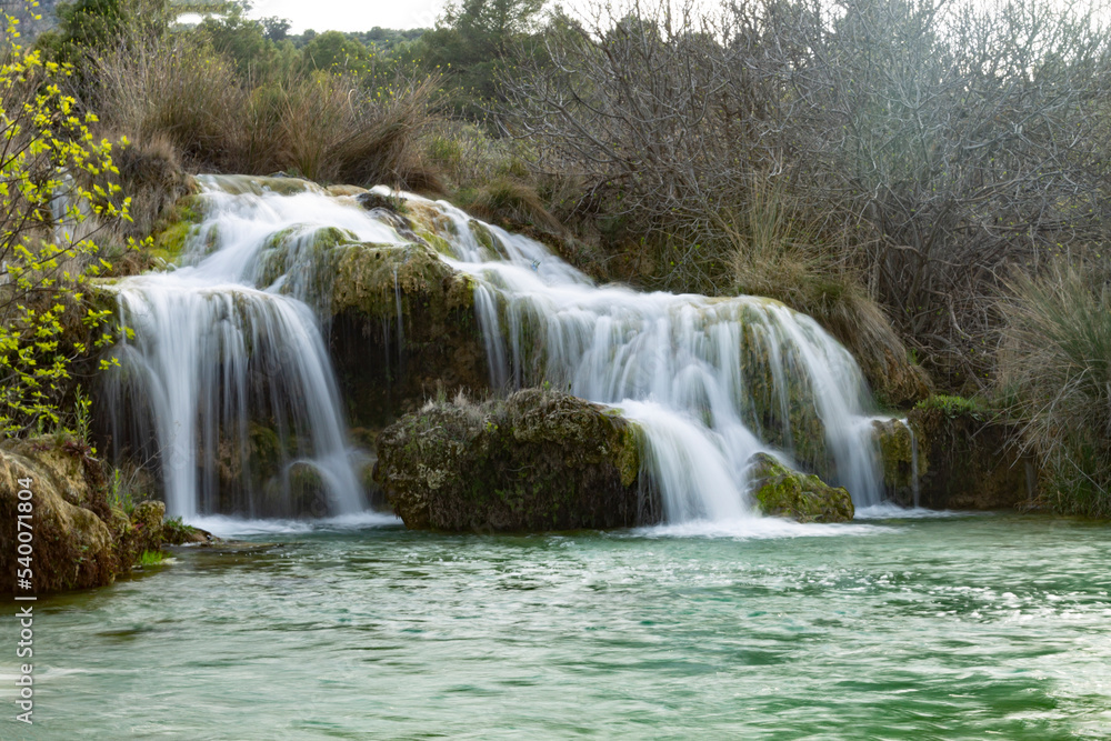 waterfall in lagoons with green water on stones