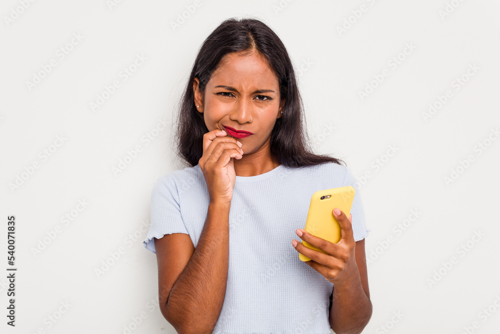 Young indian woman using mobile phone isolated on white background biting fingernails, nervous and very anxious. Young indian woman using mobile phone isolated on white background biting fingernails, nervous and very anxious.
