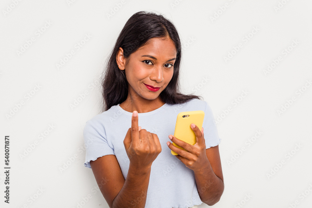 Young indian woman using mobile phone isolated on white background pointing with finger at you as if inviting come closer. Young indian woman using mobile phone isolated on white background pointing with finger at you as if inviting come closer.