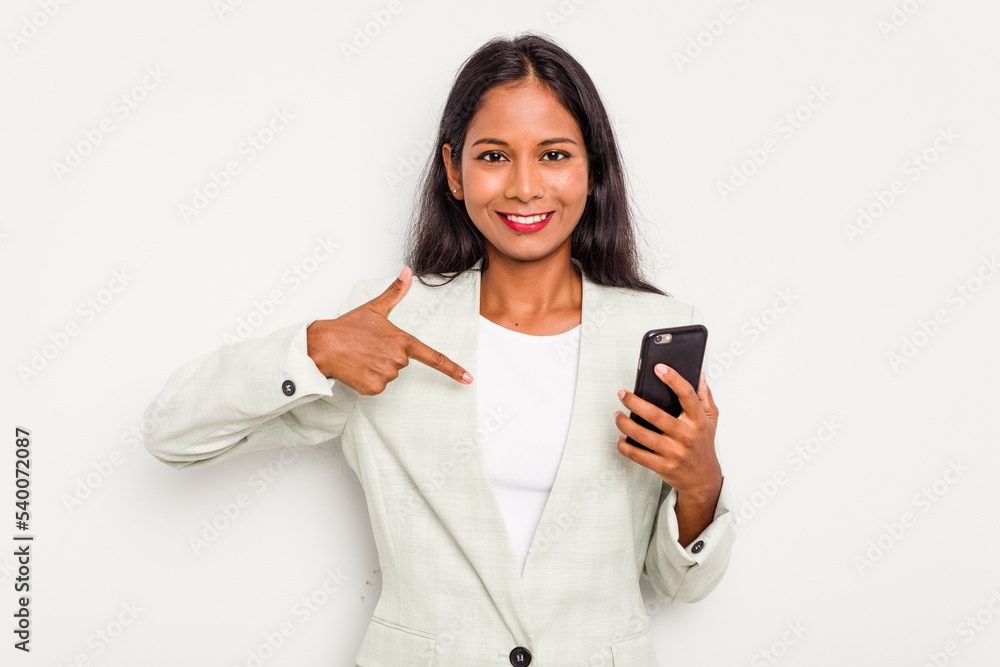 Young business Indian woman holding a mobile phone isolated on white background person pointing by hand to a shirt copy space, proud and confident