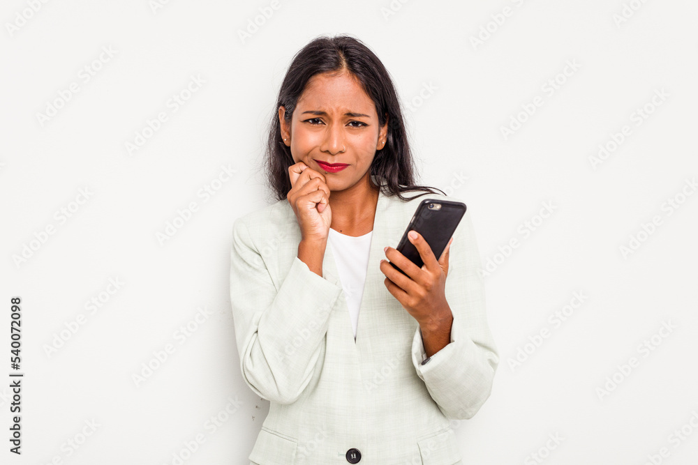 Young business Indian woman holding a mobile phone isolated on white background biting fingernails, nervous and very anxious. Young business Indian woman holding a mobile phone isolated on white background biting fingernails, nervous and very anxious.
