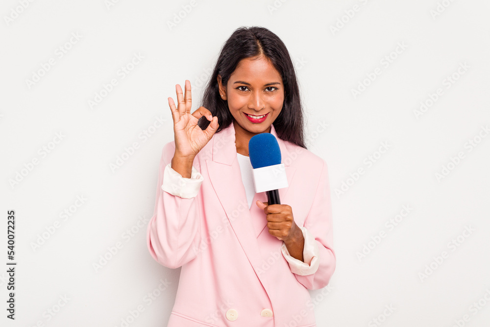 Young TV presenter indian woman isolated on white background cheerful and confident showing ok gesture.