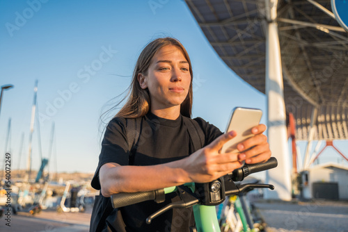 Woman enjoying of summer weather and messaging smartphone outdoors at the port
