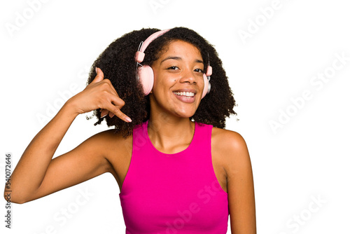 Young African American woman wearing headphones isolated showing a mobile phone call gesture with fingers.