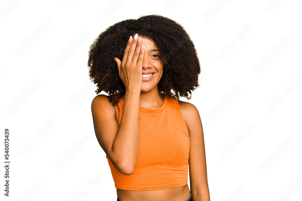 Young African American woman isolated having fun covering half of face with palm. Young African American woman isolated having fun covering half of face with palm.