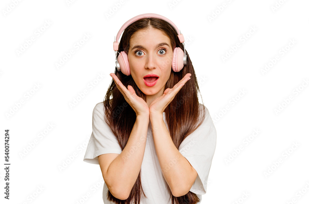 Young caucasian woman wearing headphones isolated surprised and shocked. Young caucasian woman wearing headphones isolated surprised and shocked.