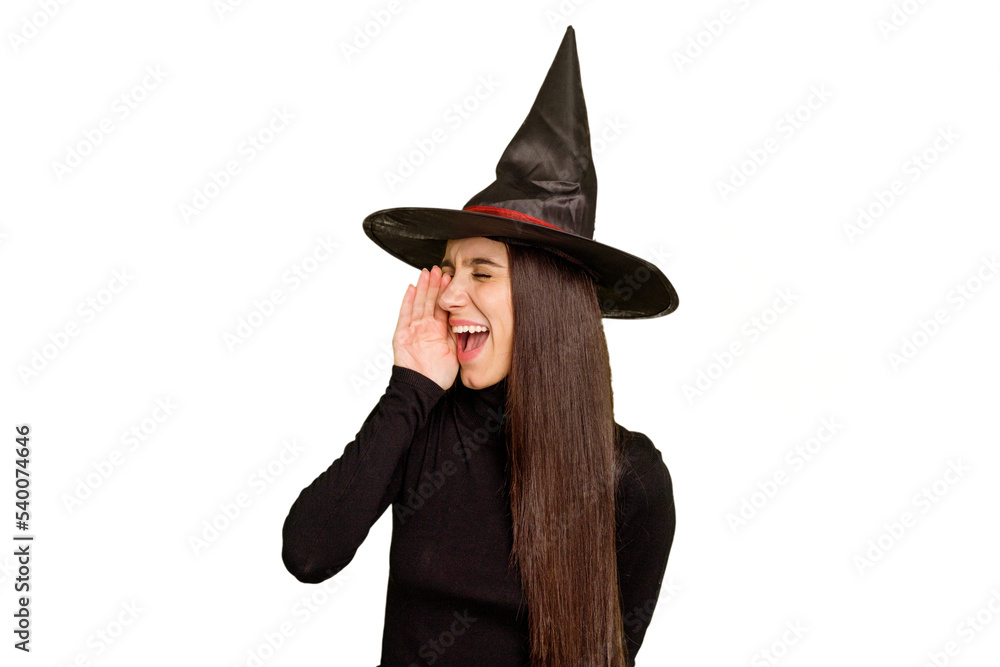 Young caucasian woman dressed as a witch for halloween day isolated shouting and holding palm near opened mouth. Young caucasian woman dressed as a witch for halloween day isolated shouting and holding palm near opened mouth.