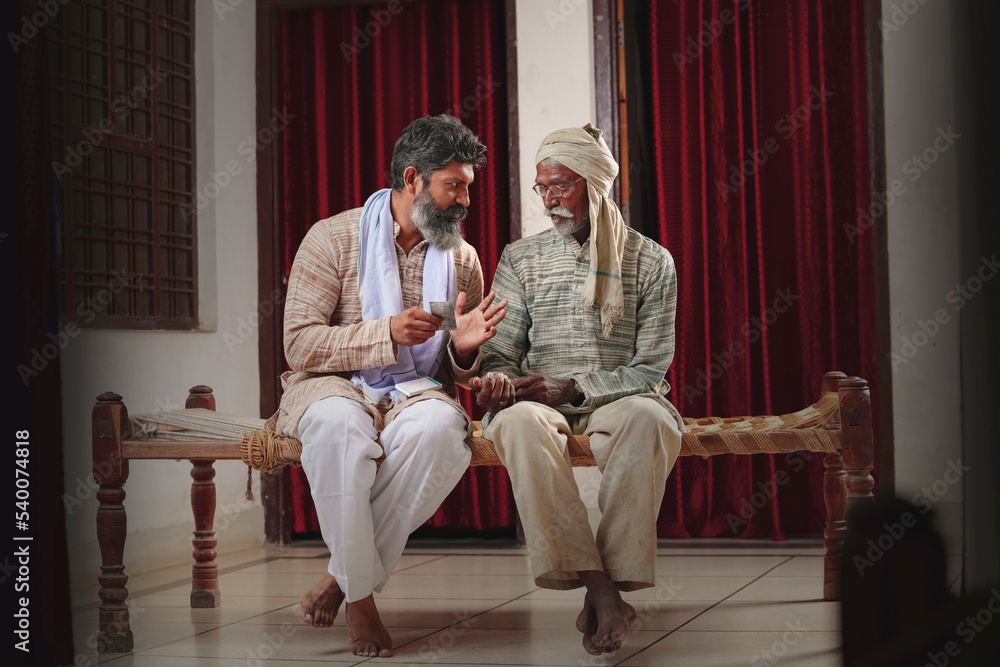 Obraz premium Indian farmer giving some medicine his father at home