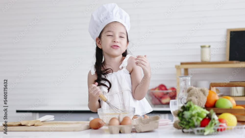 toddler girl is learning to cook bread in the kitchen with her mom with fun and curiosity. child development skills preschool. Activities for children to practice cooking as a chef.