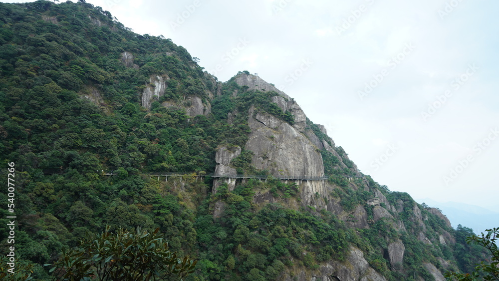 The beautiful mountains landscapes with the green forest and a plank road built along the face of a cliff in the countryside of the China