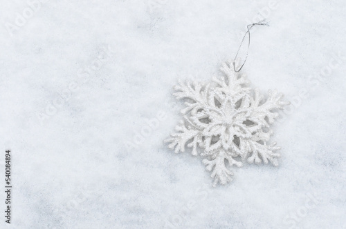 Snowflake Christmas toy on a snowy white background.
