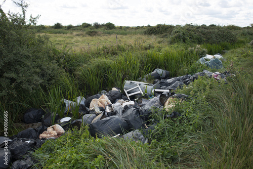 Fly tipping in drainage ditch on Crayford Marshes, Bexley, South East London, UK.